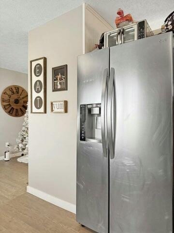 kitchen featuring stainless steel refrigerator with ice dispenser and wood-type flooring