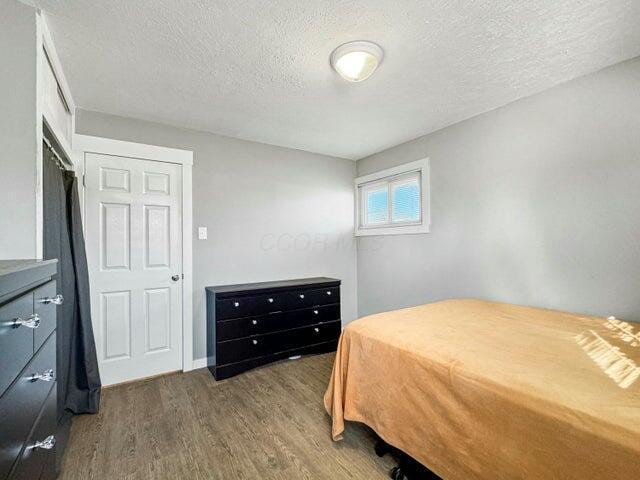 bedroom featuring a textured ceiling and dark wood-type flooring