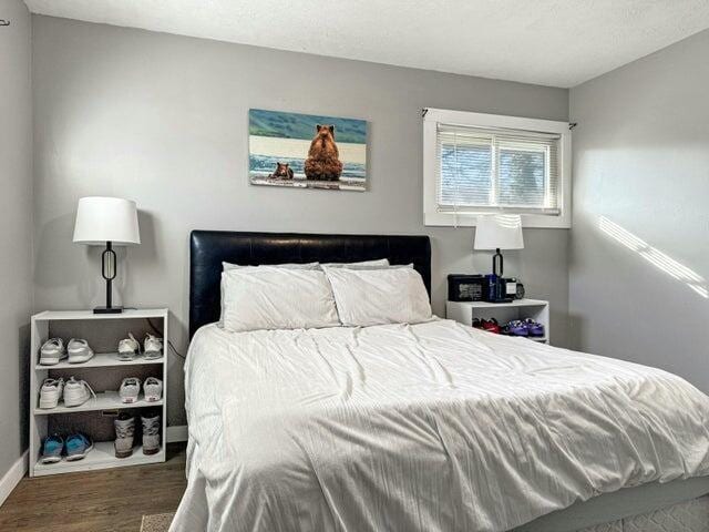 bedroom with dark hardwood / wood-style flooring