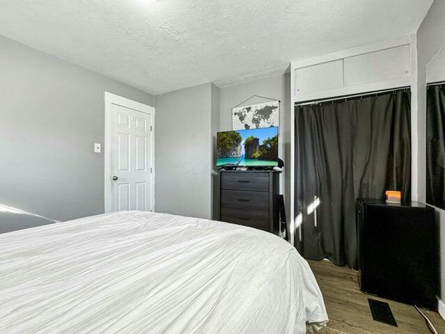 bedroom featuring a textured ceiling, light hardwood / wood-style floors, and a closet