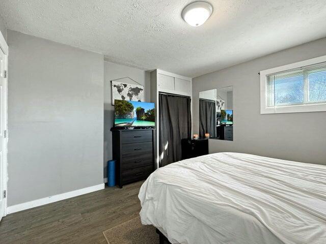 bedroom with dark hardwood / wood-style flooring and a textured ceiling