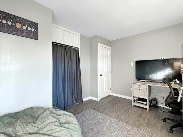 bedroom featuring dark hardwood / wood-style flooring and a closet