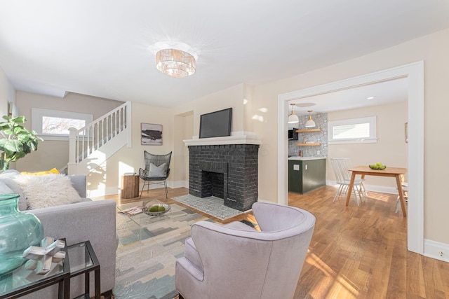 living room featuring hardwood / wood-style flooring and a brick fireplace