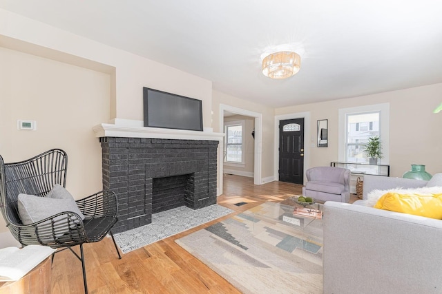 living room featuring hardwood / wood-style flooring and a brick fireplace