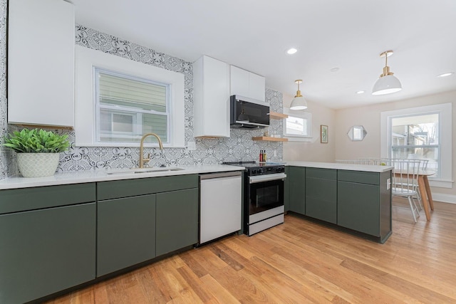 kitchen featuring pendant lighting, sink, tasteful backsplash, dishwashing machine, and range