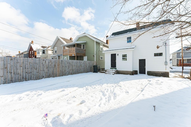 view of snow covered back of property