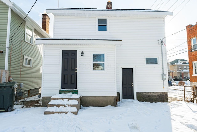 view of snow covered back of property