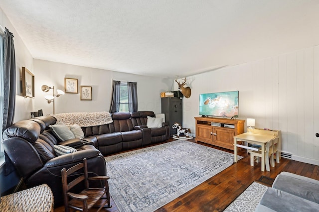 living room with a textured ceiling and dark hardwood / wood-style flooring