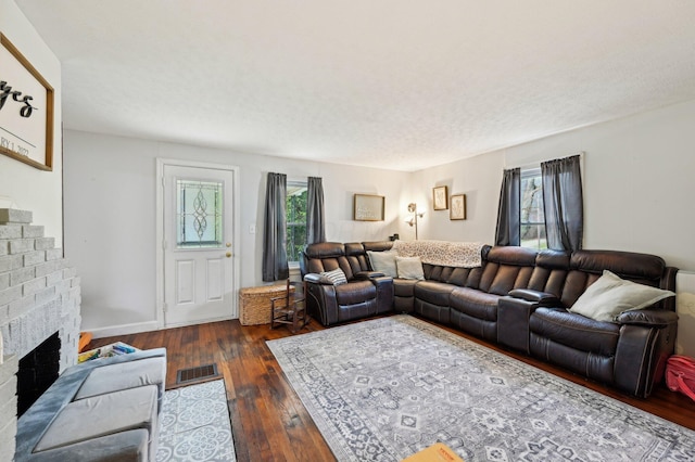 living room featuring a fireplace and dark wood-type flooring