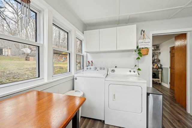 laundry area featuring washer and dryer, dark hardwood / wood-style floors, a wealth of natural light, and cabinets