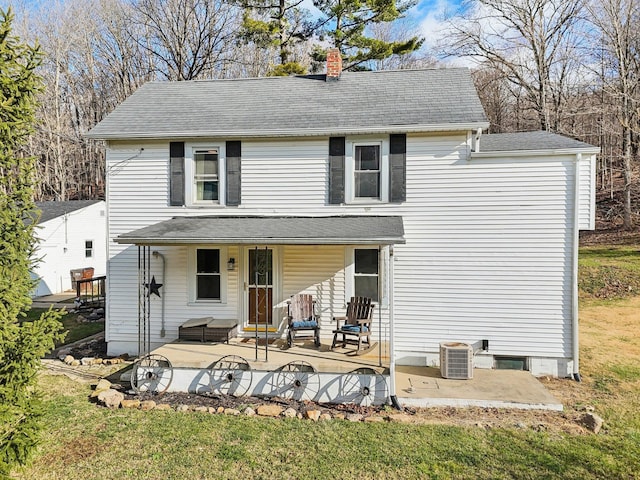 view of property featuring cooling unit, a patio area, and a front lawn