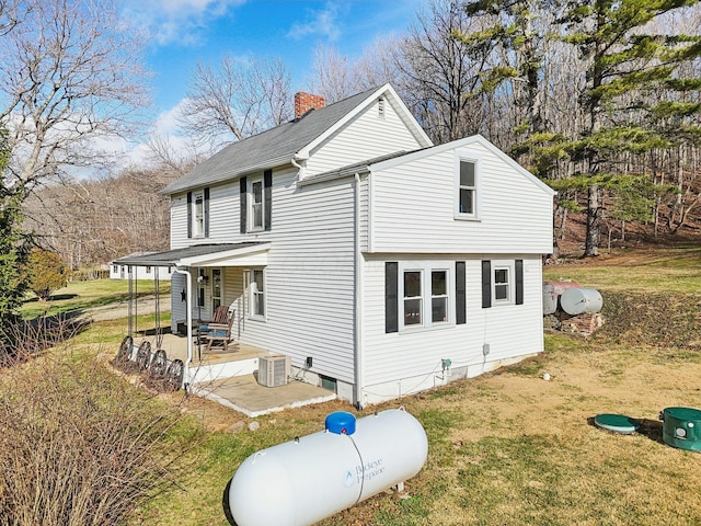 exterior space featuring a lawn, covered porch, and central AC unit