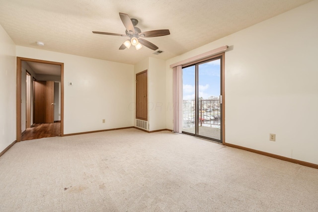 carpeted empty room with ceiling fan and a textured ceiling