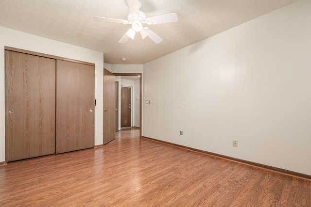 unfurnished bedroom with light wood-type flooring, a closet, and ceiling fan