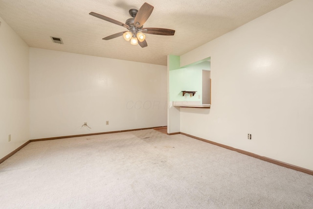 carpeted spare room featuring ceiling fan and a textured ceiling