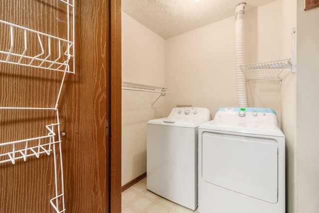 washroom with independent washer and dryer and a textured ceiling