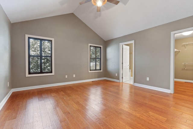 unfurnished bedroom with light hardwood / wood-style flooring, a spacious closet, a closet, and ceiling fan