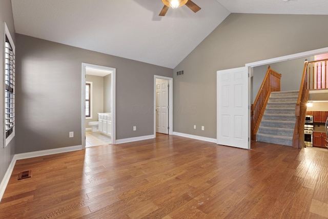 unfurnished living room with ceiling fan, hardwood / wood-style floors, and high vaulted ceiling