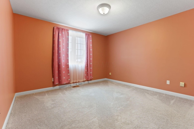 unfurnished room with carpet floors and a textured ceiling