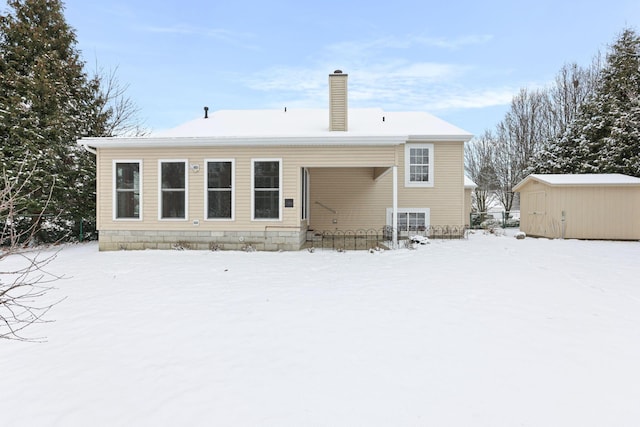 snow covered property with a shed