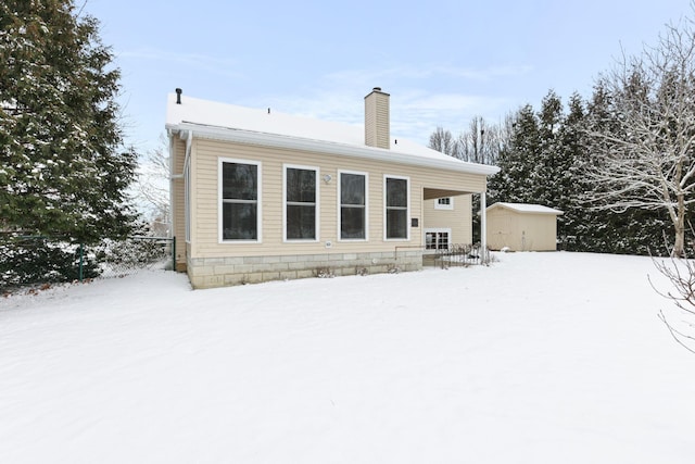 snow covered property with a shed