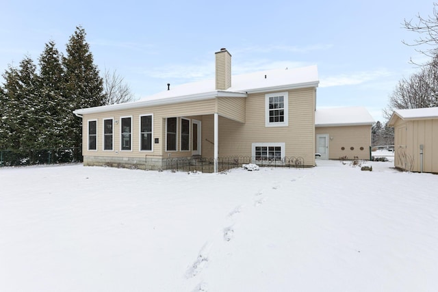 view of snow covered rear of property