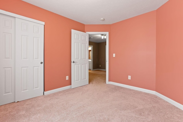 unfurnished bedroom featuring light carpet and a closet