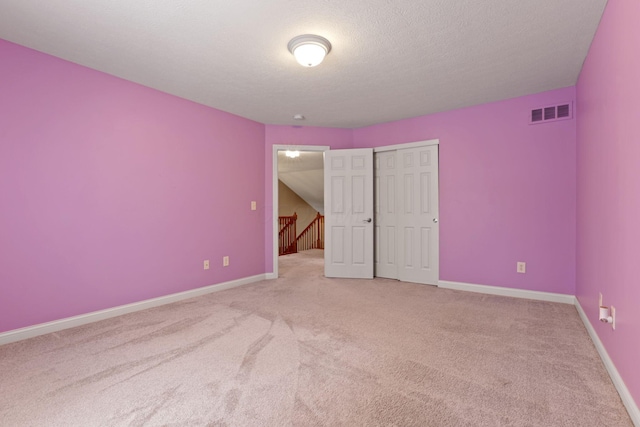 unfurnished bedroom with carpet, a textured ceiling, and a closet