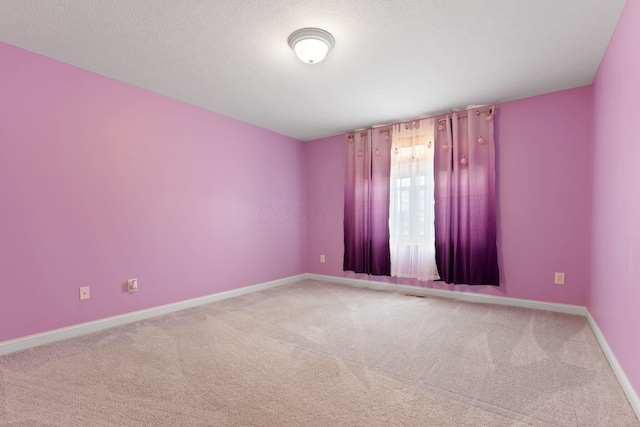 carpeted spare room featuring a textured ceiling