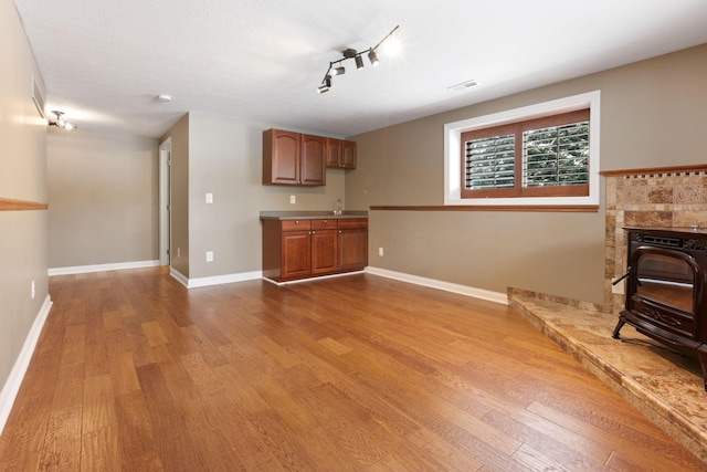 unfurnished living room with hardwood / wood-style flooring, sink, and track lighting