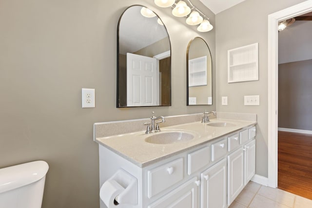 bathroom with tile patterned flooring, vanity, and toilet