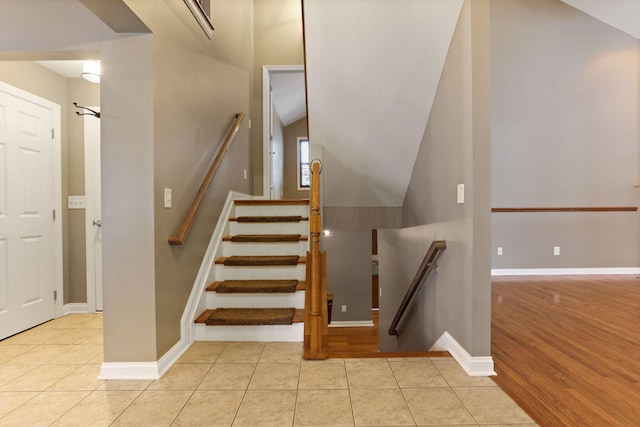 stairway with tile patterned flooring and lofted ceiling