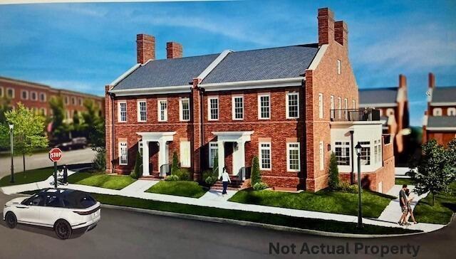 view of front facade with a chimney and brick siding