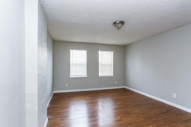 spare room with dark wood-type flooring