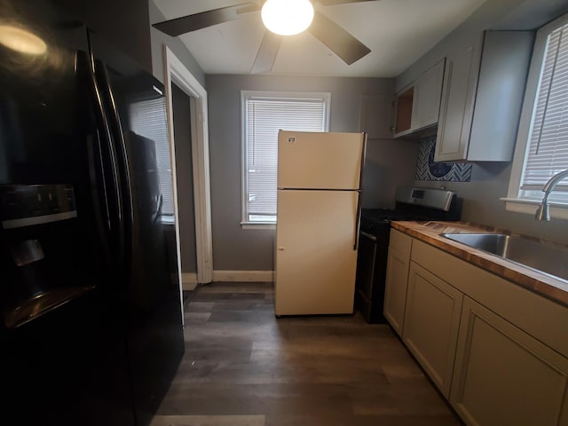 kitchen featuring refrigerator, range with gas cooktop, sink, wooden counters, and black fridge