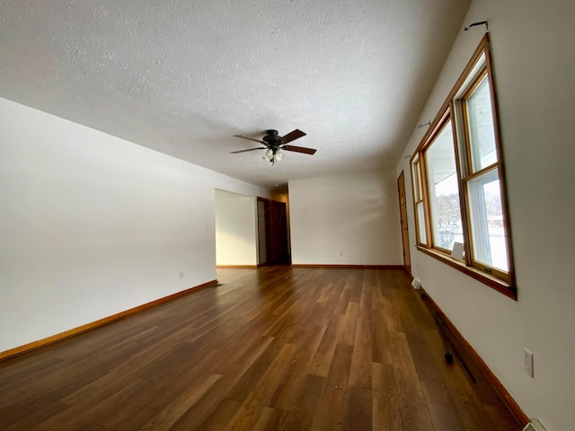 empty room with dark hardwood / wood-style floors, ceiling fan, and a textured ceiling