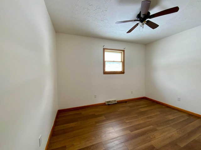 empty room with ceiling fan, hardwood / wood-style floors, and a textured ceiling