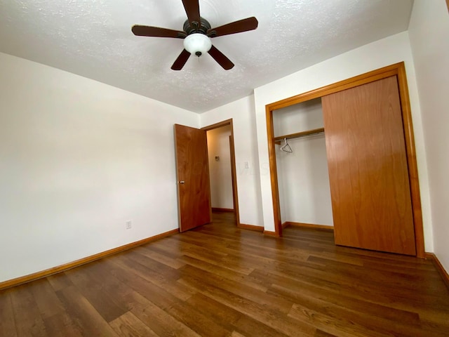 unfurnished bedroom featuring a textured ceiling, a closet, dark hardwood / wood-style floors, and ceiling fan