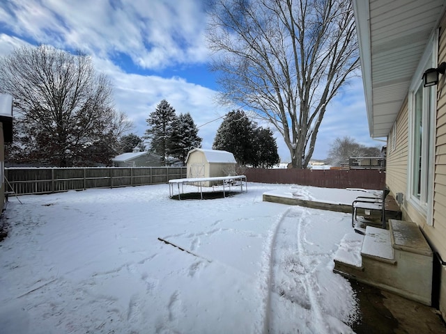 yard layered in snow featuring a trampoline