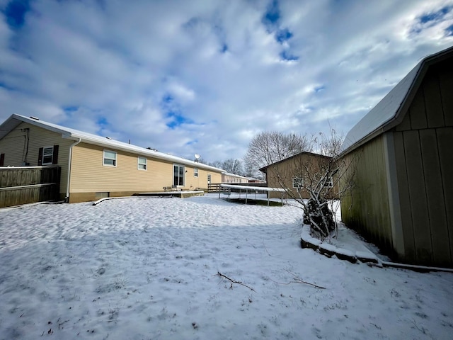 yard layered in snow featuring a trampoline