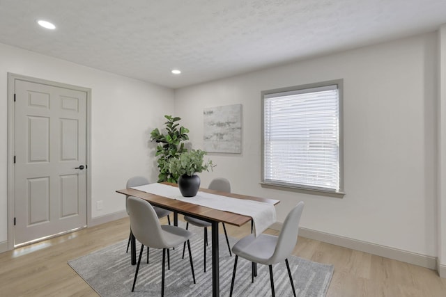 dining area featuring light hardwood / wood-style floors and a textured ceiling