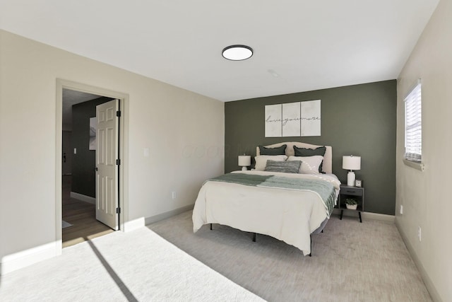 bedroom with connected bathroom and light colored carpet