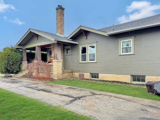 view of side of home with a lawn