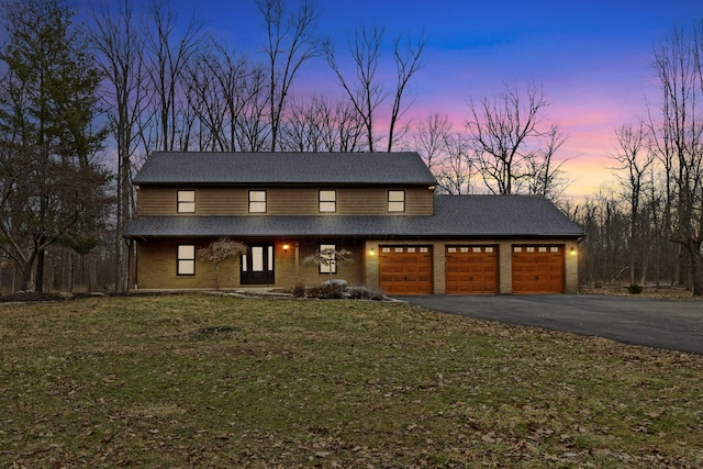 view of front of property featuring a garage and a lawn