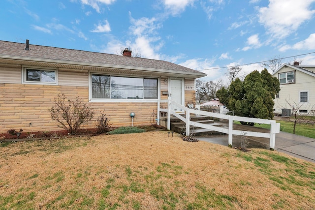 view of front of property with cooling unit and a front lawn