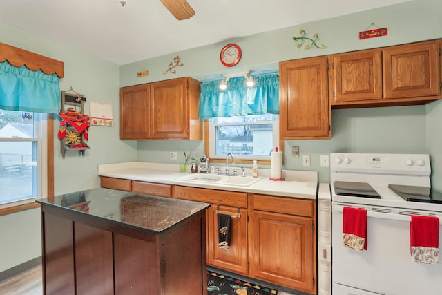 kitchen featuring ceiling fan, electric range, a wealth of natural light, and sink