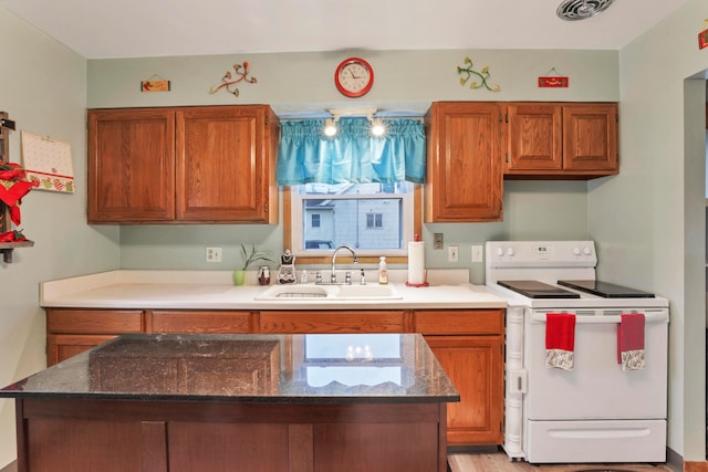 kitchen with dark stone countertops, sink, and white electric stove