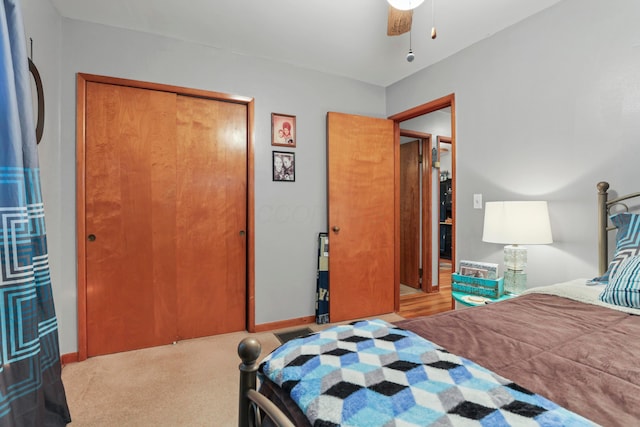 carpeted bedroom featuring ceiling fan and a closet