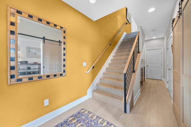 stairway featuring hardwood / wood-style flooring and a barn door