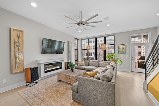 living room featuring ceiling fan and light hardwood / wood-style floors